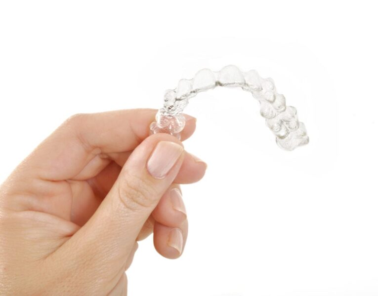 hand holding an Invisalign retainer